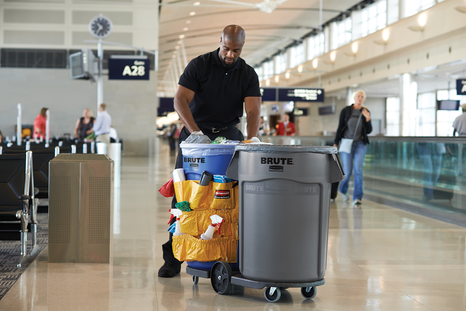 An airport personell spotted using Blue and Gray BRUTE® Vented Waste Container