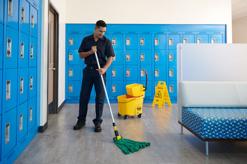 Cleaner in locker room with string mop